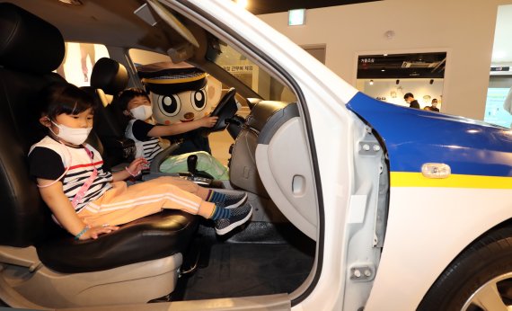 어린이날인 5일 서울 종로구 경찰박물관에서 진행된 어린이날 행사 중 어린이들이 포돌이의 도움을 받아 순찰차 모형에 탑승하고 있다. 2022.5.5/뉴스1 © News1 장수영 기자