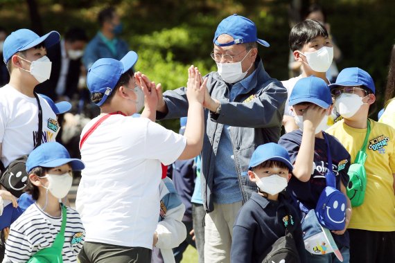 [서울=뉴시스] 전신 기자 = 문재인 대통령이 5일 청와대 녹지원에서 열린 2022년 어린이날 100주년 기념 청와대 어린이 초청행사에서 어린이들과 함께 종이 뒤집기 놀이를 하며 하이파이브를 하고 있다. 2022.05.05. photo1006@newsis.com
