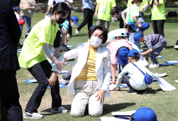 [서울=뉴시스] 전신 기자 = 문재인 대통령 부인 김정숙 여사가 5일 청와대 녹지원에서 열린 2022년 어린이날 100주년 기념 청와대 어린이 초청행사에서 아이들과 함께 종이뒤집기를 하던 중 지친 표정을 짓고 있다. 2022.05.05. photo1006@newsis.com