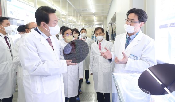 [대전=뉴시스] 인수위사진기자단 = 윤석열 대통령 당선인이 29일 오전 대전 한국과학기술원(KAIST) 내 나노종합기술원을 방문해 반도체 연구 현장을 둘러보던 중 반도체 웨이퍼 샘플을 살펴보고 있다. 2022.04.29. photo@newsis.com