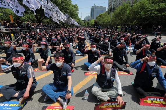 민주노총 전국공공운수노동조합 화물연대본부 조합원들이 7일 서울 영등포구 여의도공원 앞에서 열린 컨테이너·BCT 화물노동자 투쟁 결의대회에서 안전 운임 일몰제 폐지 및 전차종·전품목 확대를 촉구하며 구호를 외치고 있다. 2022.5.7/뉴스1 © News1 조태형 기자