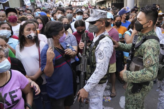 필리핀 대선이 실시된 9일 수도 마닐라 톤도 구역에서 경찰관과 해군 수병이 투표소 밖 인파를 통제하고 있다.AP뉴시스