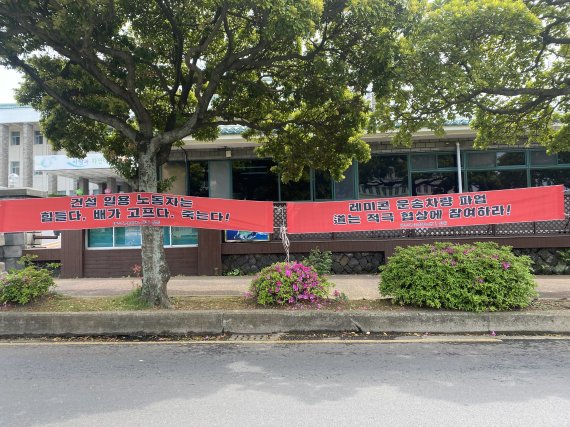 제주지역 레미콘 운송사업자(기사)들이 제주도청 정문에서 집회를 열고 운송비 인상과 처우개선 등을 촉구했다. 사진은 운송기사측이 도청에 내건 현수막.© 뉴스1