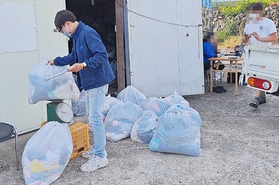 [서귀포=뉴시스] 서귀포시 헌 옷 수집 자원봉사 프로그램 관계자가 수집한 헌 옷의 무게를 재고 있다. (사진=서귀포시) 2022.05.11. photo@newsis.com *재판매 및 DB 금지