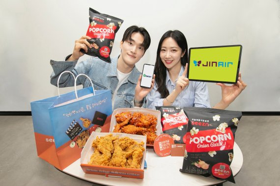 OTT seezn(시즌)이 CU(씨유), 당신은 지금 치킨이 땡긴다(당치땡), 진에어, 지마켓글로벌 등과 제휴해 고객들에게 이색적인 제품과 서비스를 선보인다. KT 모델들이 13일 seezn에서 출시한 다양한 제휴 서비스를 소개하고 있다. KT 제공.