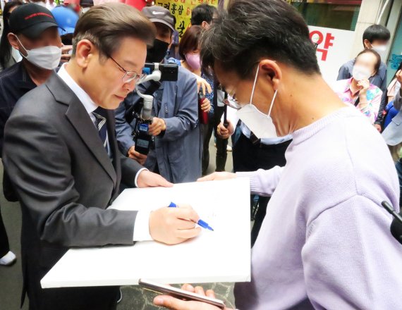 [인천=뉴시스] 김동영 기자 = 제8회 전국동시지방선거 인천 계양을에 출마한 더불어민주당 이재명 후보 겸 총괄선거대책위원장이 13일 오후 인천시 부평구 부평종합시장에서 시민들과 기념촬영을 하고 있다. 2022.5.13. dy0121@newsis.com