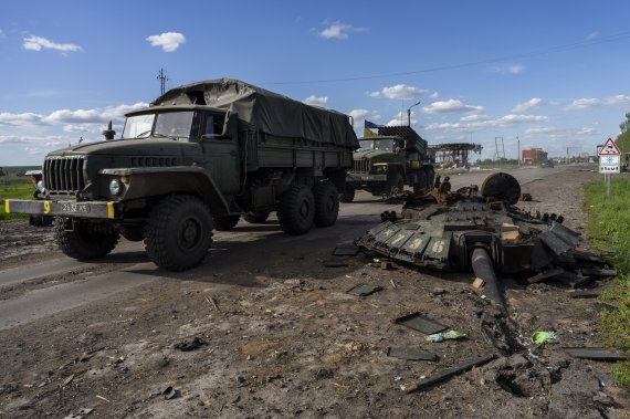 [하르키우=AP/뉴시스]지난 13일(현지시간) 우크라이나 하루키우 북부에서 우크라이나군 차량이 러시아군 전차 잔해를 지나고 있다. 2022.05.14.