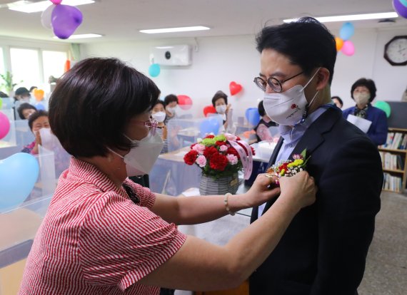 [서울=뉴시스] 배훈식 기자 = 제41회 스승의 날을 하루 앞둔 14일 오후 서울 마포구 일성여자중고등학교에서 한 학생이 선생님에게 카네이션을 달아주고 있다. 40~80대 여성 만학도를 위한 일성여중고교는 2년제 학력인정 평생학교다. 2022.05.14. dahora83@newsis.com