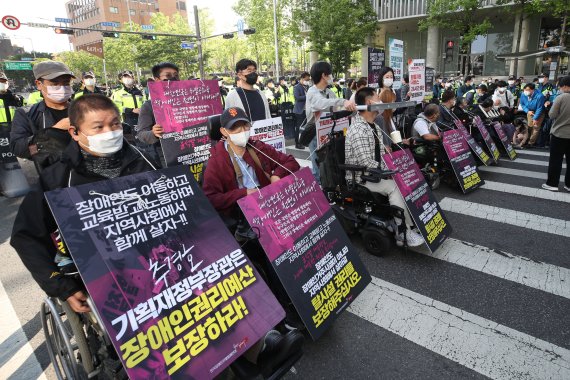 전국장애인자별철폐연대 회원들이 16일 오전 서울 용산구 신용산역 인근에서 장애인권리예산 22년 추경반영 촉구 출근길 행진 중 횡단보도를 막고 시위를 하고 있다./사진=뉴시스