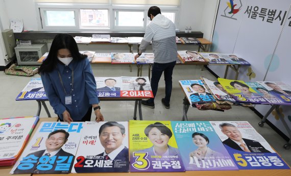 6‧1 전국동시지방선거 공식선거운동을 하루 앞둔 18일 서울 종로구 서울시선거관리위원회에서 관계자들이 서울특별시장에 출마한 후보들의 선거 벽보를 확인하고 있다. 2022.2.18/뉴스1 © News1 임세영 기자