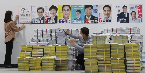 제8회 전국동시지방선거 공식 선거운동을 하루 앞둔 18일 오후 경기 수원 권선구 중앙선거관리위원회 선거연수원 선거장비센터에서 관계자들이 선거벽보와 공보물 점검을 하고 있다. 2022.5.18/뉴스1 © News1 김영운 기자