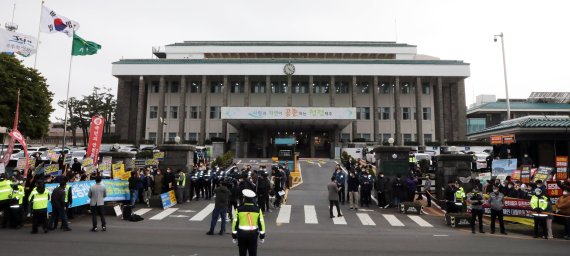 제주 제2공항 건설사업에 대한 도민들의 여론로 갈리고 있다. 지난해 3월 정세균 국무총리가 제주도청을 방문한 가운데 제주 제2공항 찬성(사진 왼쪽)과 반대 단체가 도청 정문 앞에서 비슷한 시간 기자회견을 열고 있다.2021.3.19/뉴스1 © News1 고동명 기자