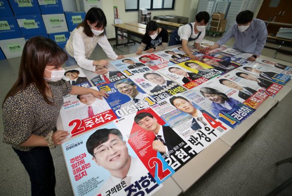 제8회 전국동시지방선거 공식 선거운동을 하루 앞둔 18일 부산시 수영구 연제구 선거관리위원회에서 직원들이 부산 지역 각 후보들의 선거 벽보를 점검하고 있다. 2022.5.18/뉴스1 © News1 김영훈 기자