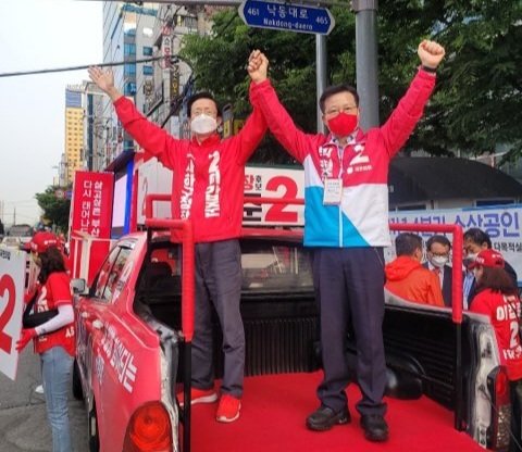 6·1 지방선거 공식 선거운동 첫날인 19일 이갑준 국민의힘 사하구청장 후보(왼쪽)가 홍보차에서 주민들에게 인사를 하고 있다.(더불어민주당 부산선대위 제공)© 뉴스1