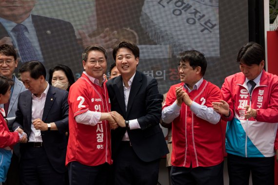 이준석 국민의힘 상임선대위원장과 유정복 인천시장 후보가 19일 인천시 부평구 부평 문화의 거리에서 열린 ‘국민의힘 희망 인천 출정식’에서 손을 맞잡고 있다. 2022.5.19/뉴스1 © News1 국회사진취재단