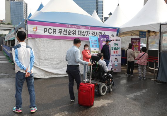20일 오전 서울역 광장에 마련된 코로나19 임시선별검사소에서 시민들이 유전자 증폭(PCR)검사를 받기 위해 줄을 서 있다. 이날 0시 기준 코로나19 신규 확진자는 2만 5125명 발생했다. 뉴스1 제공