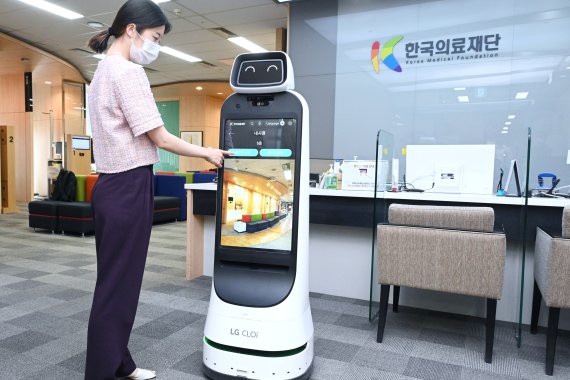 한국의료재단 종합검진센터 직원이 LG 클로이 가이드봇을 활용해 건강검진 안내를 받는 모습을 시연하고 있다. LG전자 제공
