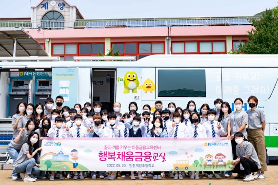 NH농협은행 임직원들과 N돌핀 대학생봉사단이 지난 20일 이동금융교육을 위해 찾아간 인천 계양초등학교 학생들과 함께 기념 사진을 찍고 있다. NH농협은행 제공