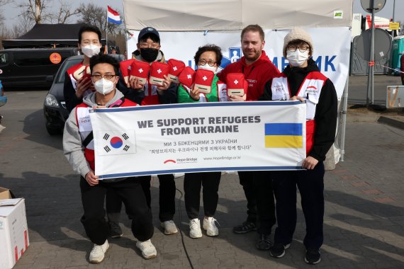 지난 3월 26일 우크라이나와 마주한 폴란드 국경도시 프셰미실의 인도주의적 지원 센터에서 희망브리지 해외봉사단이 노르웨이 구호단체 파라크루 관계자에게 구급 키트를 전달한 뒤 기념사진을 찍고 있다. 희망브리지 제공