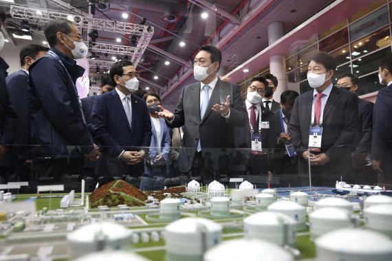 윤석열 대통령이 24일 대구 엑스코에서 열린 2022 세계가스총회(WGC) 개막식에 참석해 한국가스공사 전시장에서 LNG-LH2 하이브리드 인수기지 모형을 살펴보며 대화를 나누고 있다. 사진=뉴스1