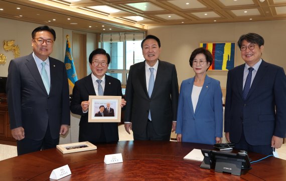 윤석열 대통령이 24일 서울 용산 대통령실 청사 집무실에서 박병석 국회의장에게 바이든 방한 만찬 당시 찍은 기념사진이 담긴 액자를 선물한 뒤 기념촬영을 하고 있다. 왼쪽부터 정진석 국회부의장, 박병석 국회의장, 윤석열 대통령, 김상희 국회부의장, 이춘석 국회사무총장. (대통령실통신사진기자단) 사진=뉴시스