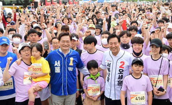 송영길 더불어민주당 후보와 오세훈 국민의힘 서울시장 후보가 21일 오전 서울 마포구 월드컵경기장 평화의공원에서 열린 2022 서울신문 마라톤 대회에서 참석자들과 기념촬영을 하고 있다.(서울신문 제공) 2022.5.21/뉴스1 © News1 신웅수 기자