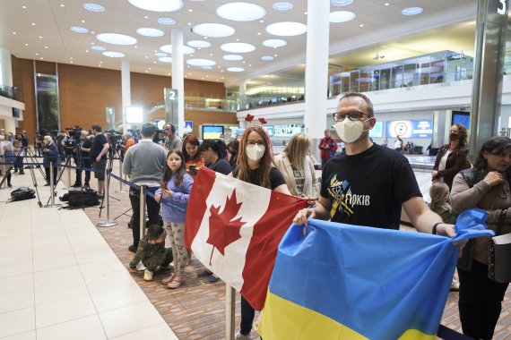 [위니펙( 캐나다)= AP/뉴시스]캐나다 위니펙의 리차드슨 국제공항에서 5월 23일 국기를 든 채 우크라이나 피난민들을 기다리고 있는 캐나다의 지인들. 캐나다 정부는 개전초 부터 우크라이나에 무기 지원과 피난민 지원에 참여해왔다.