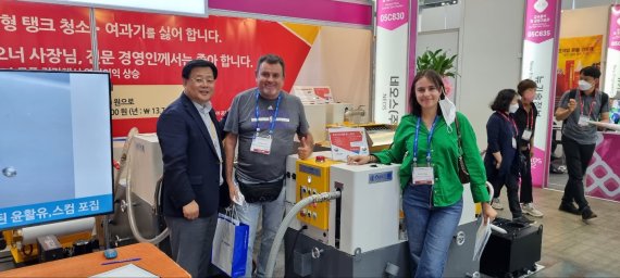 25일 일산 킨텍스에서 열리고 있는 서울 국제 공작기계 전시회(SIMTOS)에서 김윤상 네오스 대표(왼쪽 첫번째)가 부스를 찾은 방문객과 기념촬영을 하고 있다. 네오스 제공.