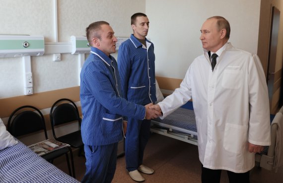 [모스크바=AP/뉴시스] 25일(현지시간) 블라디미르 푸틴 러시아 대통령이 모스크바의 만드리카 군 병원에서 우크라이나 침공에서 부상한 러시아 군인과 악수하고 있다. 2022.05.26