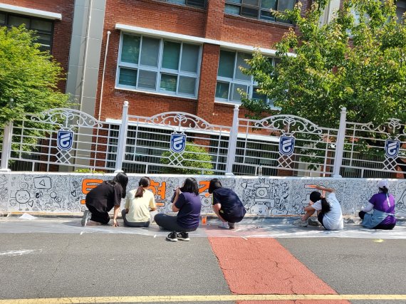 부산 연제구 토현중학교 1학년 학생들이 등굣길 담장에 벽화를 그리고 있다./제공=부산시교육청