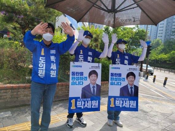 박세원 도의원 후보(사진 왼쪽 첫번째)가 화성 반송동 솔빛마을 사거리에서 동탄 주민들에게 출근인사를 하고 있다.(박세원 후보 선거사무실 제공) © 뉴스1