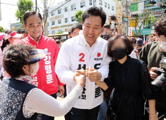[서울=뉴시스] 국회사진기자단 = 오세훈 국민의힘 서울시장 후보가 26일 오전 서울 성동구 뚝섬로 성수전략지구에서 유세를 하며 시민들과 인사를 나누고 있다. 2022.05.26. photo@newsis.com