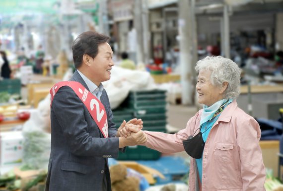 [창원=뉴시스] 홍정명 기자= 박완수 국민의힘 경남도지사 후보가 29일 오전 창원시 마산회원구 마산역 옆 번개시장을 찾은 도민과 악수하고 있다.(사진=박완수 선거사무소 제공) 2022.05.29. photo@newsis.com