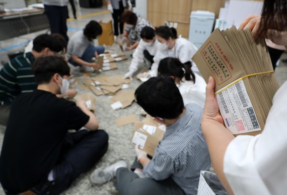 제8회 전국동시지방선거 사전 투표 이틑날인 28일 오후 서울 용산구의회에 마련된 이태원 제1동 사전투표소에서 사무원과 참관인들이 사전투표가 끝난 뒤 관외 사전투표 봉투를 분류하고 있다. 2022.5.28/뉴스1 © News1 구윤성 기자