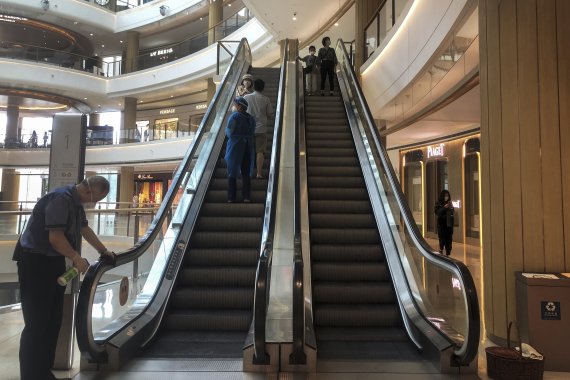 [상하이=AP/뉴시스] 지난 29일 중국 상하이의 한 쇼핑몰에서 직원이 에스컬레이터 손잡이 소독 작업을 하고 있다. 2022.05.31