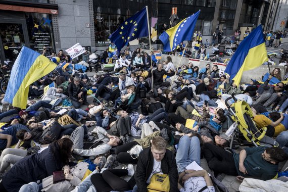 [브뤼셀=AP/뉴시스] 3월 24일(현지시간) 우크라이나 관련 러시아 제재를 논의하는 유럽연합 정상회의장 앞에서 '사망 퍼포먼스'하는 우크라이나 시위대. 유럽연합은 결국 5월 30일 러시아산 석유의 수입금지에 합의했다.