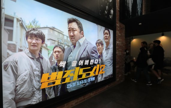 22일 오후 서울 CGV용산에서 영화 '범죄도시2' 포스터 앞으로 시민들이 오가고 있다. 2022.5.22/뉴스1 © News1 박세연 기자