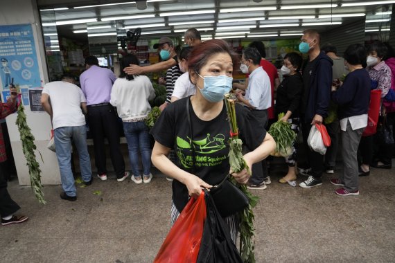 [상하이=AP/뉴시스] 1일 상하이에서 한 시민이 시장에서 채소를 사고 떠나고 있다. 지난 3월28일 내려진 봉쇄가 이날부터 전면 해제되면서 상하이시가 일상을 회복하고 있다. 2022.06.01
