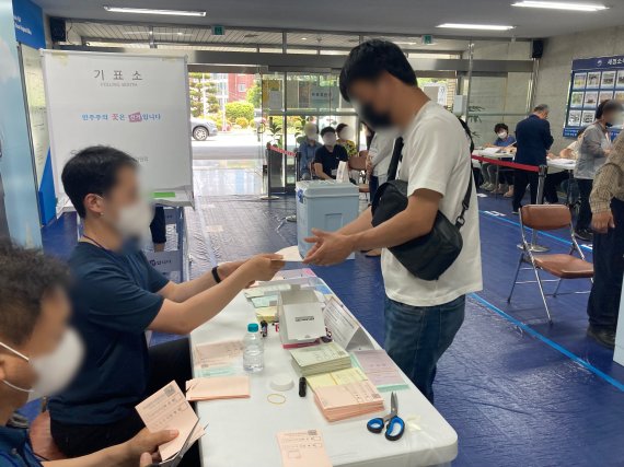 1일 낮12시쯤 부산 연제구 연산9동제4투표소에서 한 유권자가 투표용지를 받고 있다.20226.1/© 뉴스1 백창훈 기자