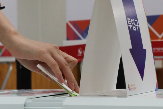 제8회 전국동시지방선거가 실시된 1일 대전 서구 관저동행정복지센터에 마련된 제1투표소에서 한 유권자가 기표한 투표용지를 투표함에 넣고 있다. ©News1 김기태 기자