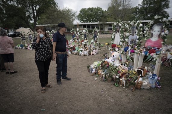 [유밸디( 미 텍사스주)= AP/뉴시스] 총격사건으로 19명이 숨진 텍사스주의 초등학교 앞 추모의 장소에 어린이들의 사진과 추모객들의 꽃다발, 장난감이 남겨져 있다.