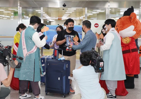 3일 오전 제주국제공항 국제선 도착장에서 제주도와 제주관광공사 직원 등이 태국 관광객들에게 기념품을 나눠주고 있다. 지난 1일자로 제주 무사증(무비자) 일시 정지가 해제돼 2년여 만에 제주공항 국제선이 재개, 외국인 관광객이 인천공항을 거치지 않고 제주로 직접 입도할 수 있게 됐다. 2022.6.3/뉴스1 © News1 고동명 기자