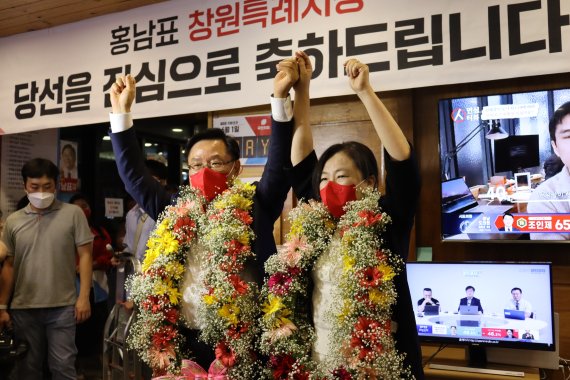 경남 창원시장 선거에 나선 홍남표 국민의힘 후보가 당선이 확실시 되자 꽃다발을 목에 걸고 손을 번쩍 들어보이고 있다.(홍 후보 선거사무소 제공)© 뉴스1