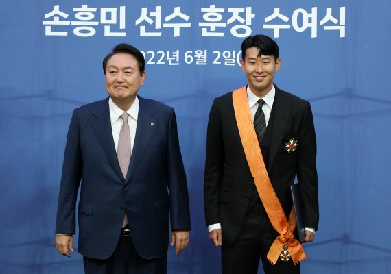 [서울=뉴시스] 이영환 기자 = 윤석열 대통령이 2일 오후 서울 마포구 서울월드컵경기장에서 진행되는 하나은행 초청 친선경기 대한민국과 브라질의 경기에 앞서 손흥민에게 체육 훈장인 청룡장을 수여한 후 기념촬영을 하고 있다. 2022.06.02. 20hwan@newsis.com