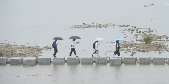 오랜 가뭄 끝에 반가운 단비가 내린 5일 경남 거창군 거창읍 위천천 징검다리에 우산을 쓴 주민들이 지나고 있다. 이 비를 시작으로 7일까지 경북 북부 동해안과 북동 산지, 제주도에는 30에서 80mm, 그밖의 남부지방은 10에서 40mm의 비가 예상된다고 기상청은 밝혔다. (거창군 제공) 2022.6.5/뉴스1