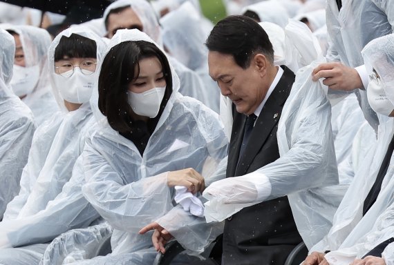 윤석열 대통령 부인 김건희 여사가 6일 서울 동작구 국립서울현충원에서 열린 제67회 현충일 추념식에서 윤 대통령 젖은 옷을 수건으로 닦아주고 있다. /사진=대통령실 제공