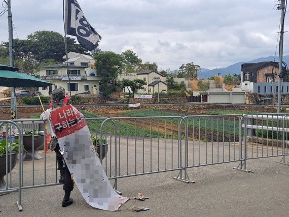 8일 오후 경남 양산시 하북면 평산마을 문재인 전 대통령 사저 앞에서 한 보수단체 회원이 몸에 현수막과 깡통을 매단 채 시위를 하고 있다. 2020.06.08 © 뉴스1 김명규 기자