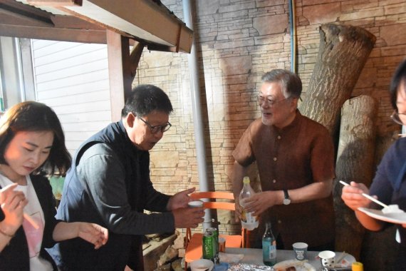 문재인 전 대통령이 경남 양산 평산마을 주민들과 함께 가마에 불을 때고 막걸리를 나눠마시는 모습을 8일 사회관계망서비스(SNS)를 통해 공개했다. (문 전 대통령 트위터) 2022.6.8/뉴스1 /사진=뉴스1화상