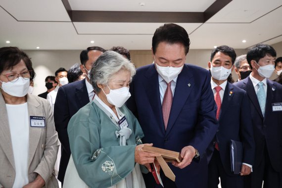 윤석열 대통령과 천안함 희생자 고 민평기 상사 모친 윤청자 여사가 9일 서울 용산 대통령실 청사에서 열린 '호국영웅 초청 소통식탁' 행사에서 아들 민 상사의 사진을 보고 있다. (대통령실 제공) 2022.6.9/뉴스1 © News1 안은나 기자