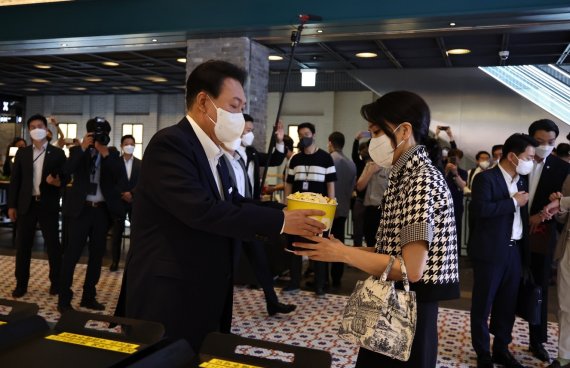 윤석열 대통령이 12일 오후 서울 메가박스 성수점에서 제75회 칸 국제영화제 남우주연상(송강호) 수상작 영화 '브로커'를 관람하기 전 부인 김건희 여사에게 팝콘을 주고 있다. (대통령실 제공) 2022.6.12/뉴스1 © News1 안은나 기자